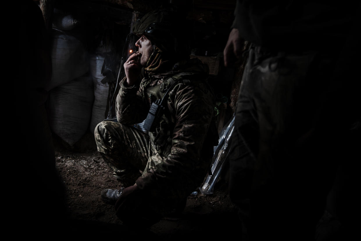 Un soldado de la Legión Internacional le pasa un lanzagranadas a otro en una posición de primera línea, en el bosque Serebrianka al este de Ucrania, el 6 de febrero de 2024. (Tyler Hicks/The New York Times)