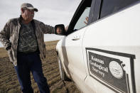 Kansas Geological Survey field research technician Connor Umbrell, right, talks to Ben Zellner after measuring the water level in an irrigation on Zellner's farm Thursday, Jan. 5, 2023, near Marienthal, Kan. Lawmakers are looking to take up groundwater issues in western Kansas in the upcoming session as the Kansas Water Authority is urging stricter usage measures to try to slow the steady decline of water levels in the Ogallala Aquifer. (AP Photo/Charlie Riedel)