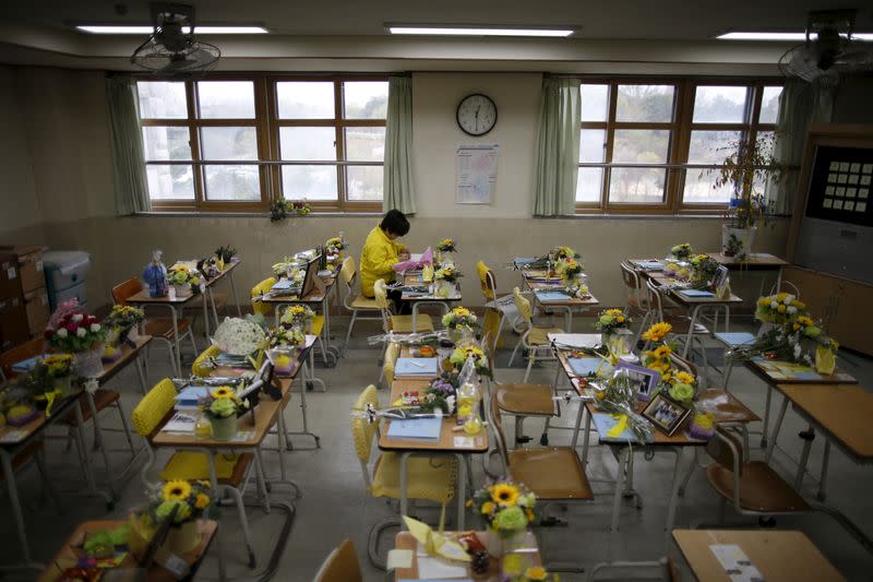 A mother of a victim who was onboard sunken ferry Sewol, leaves a message on a desk used by her child at an empty classroom, which was preserved since the disaster, at Danwon high school during the second anniversary of the disaster in Ansan