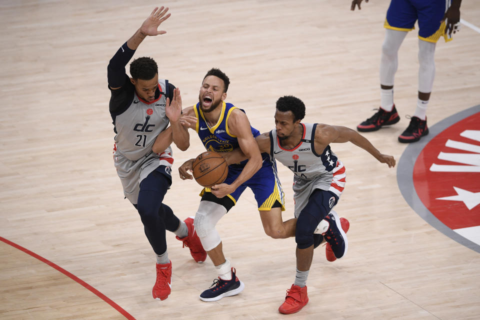 Washington Wizards center Daniel Gafford (21) and guard Ish Smith right, battle for the ball against Golden State Warriors guard Stephen Curry, center, during the second half of an NBA basketball game, Wednesday, April 21, 2021, in Washington. Gafford was called for a foul on the play. (AP Photo/Nick Wass)