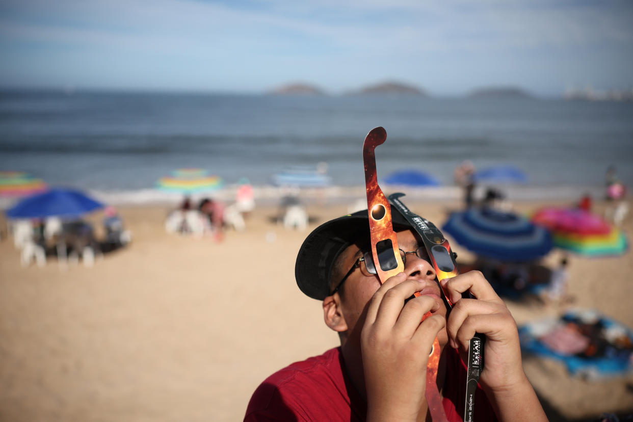 A person uses two sets of glasses to see the eclipse in Mazatlan, Mexico. 