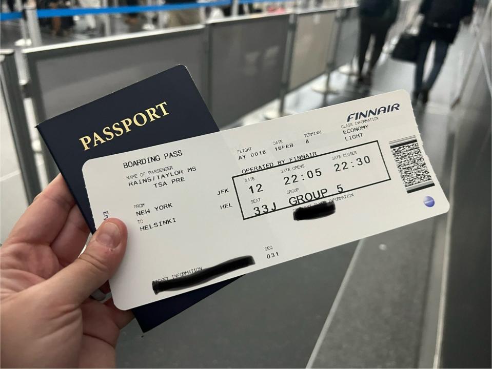 The author holding the Finnair boarding pass and her passport.