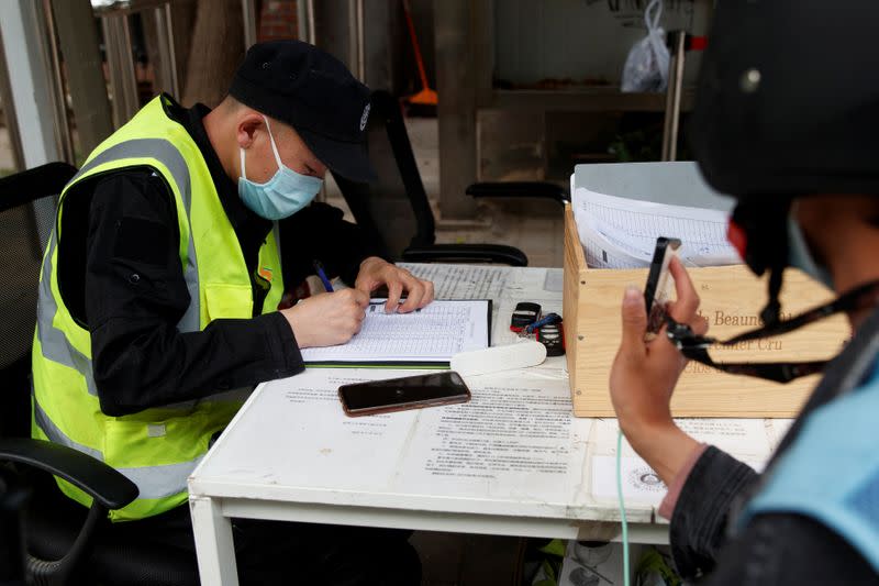 Delivery driver holds up his smartphone to present the status of his health app in Beijing