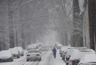 A jogger runs down a residential street under snowfall on March 5, 2015 in Washington, DC