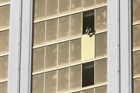 FILE PHOTO: Workers board up a broken window at the Mandalay Bay hotel, where shooter Stephen Paddock conducted his mass shooting along the Las Vegas Strip, in Las Vegas, Nevada, U.S., October 6, 2017. REUTERS/Chris Wattie