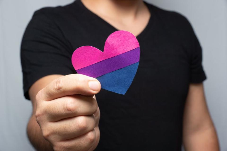 man holding bisexual heart