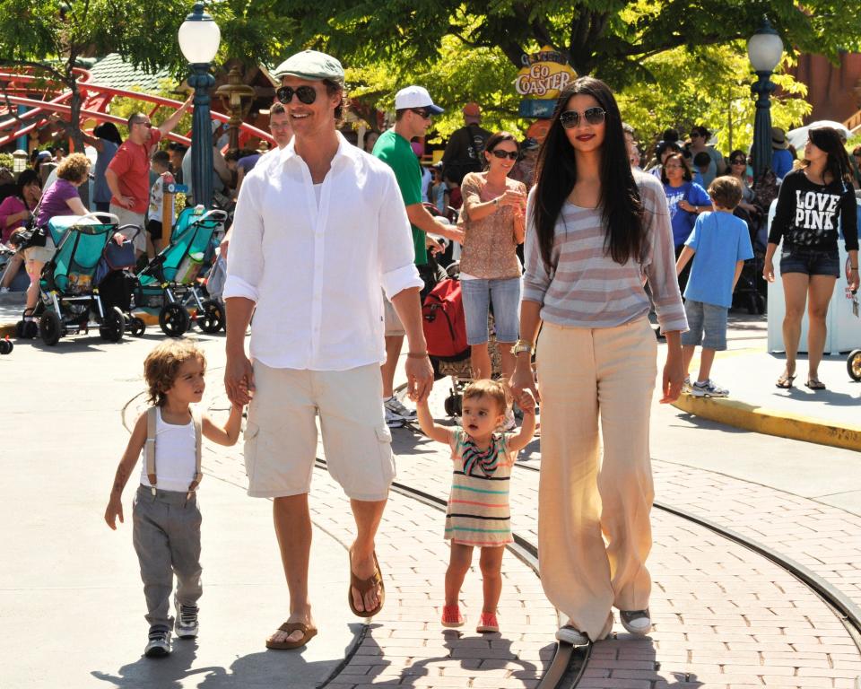 Matthew McConaughey, Camila Alves, and their children walk through Disneyland.
