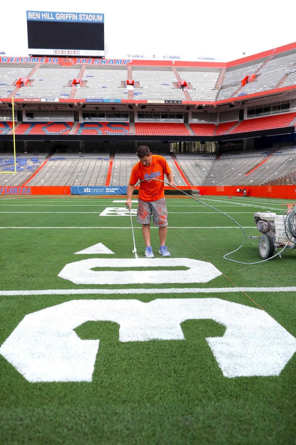 Jason Smith, the director of sports turf, paints the 30-yard logo on the field at Ben Hill Griffin Stadium as the crew prepares the field for the first game of the season, on the University of Florida campus in Gainesville FL. on Sept. 1, 2022. The Gators start the season Saturday against the No. 8 ranked Utah Utes.