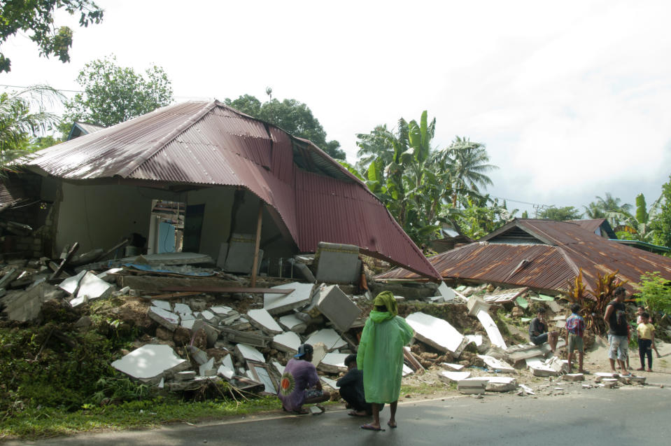 Residents stand near earthquake-damaged houses in Ambon, Maluku province, Indonesia, Friday, Sept. 27, 2019. Thursday's quake killed a number of people and displaced thousands of others. (AP Photo/Tiara Salampessy)