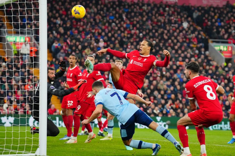 Virgil van Dijk, top, and goalkeeper Alisson block a header by Neal Maupay (AP)