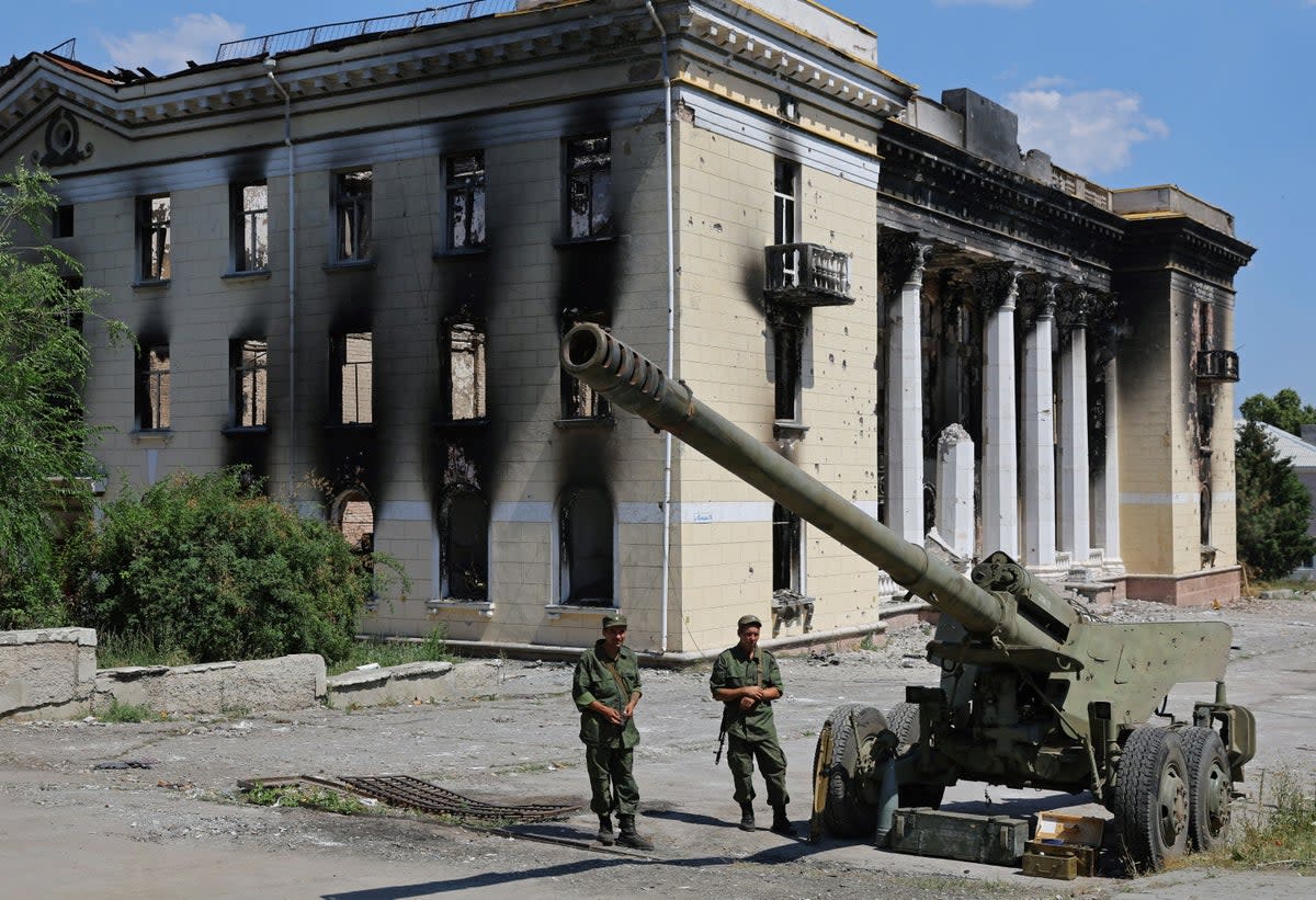 Service members of pro-Russian troops stand next to a howitzer during an exhibition of Ukrainian army hardware and weapons left in Lysychansk (REUTERS)