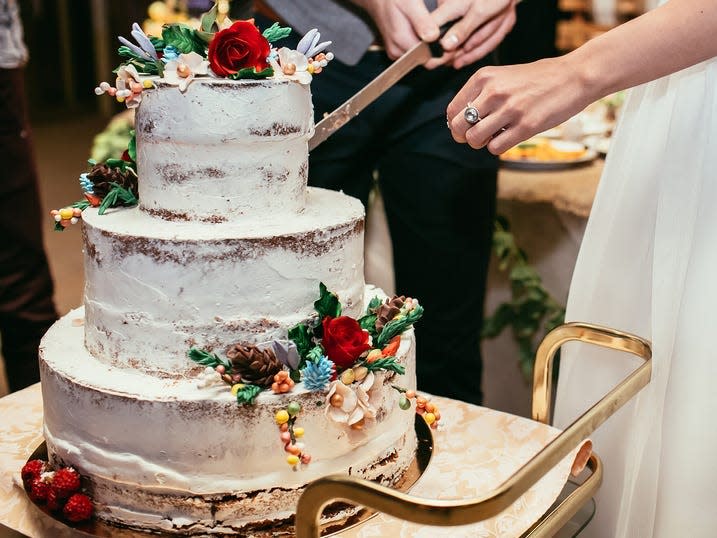 a couple cuts a multilayer wedding cake