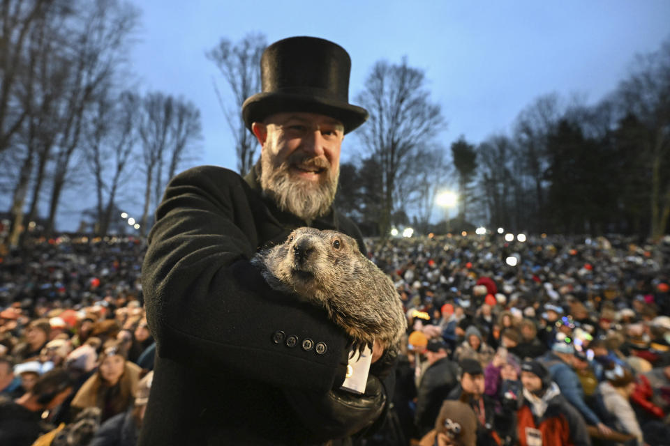 Groundhog Club handler A.J. Dereume holds Punxsutawney Phil, the weather prognosticating groundhog, during the 138th celebration of Groundhog Day on Gobbler's Knob in Punxsutawney, Pa., Friday, Feb. 2, 2024. Phil's handlers said that the groundhog has forecast an early spring. (AP Photo/Barry Reeger)