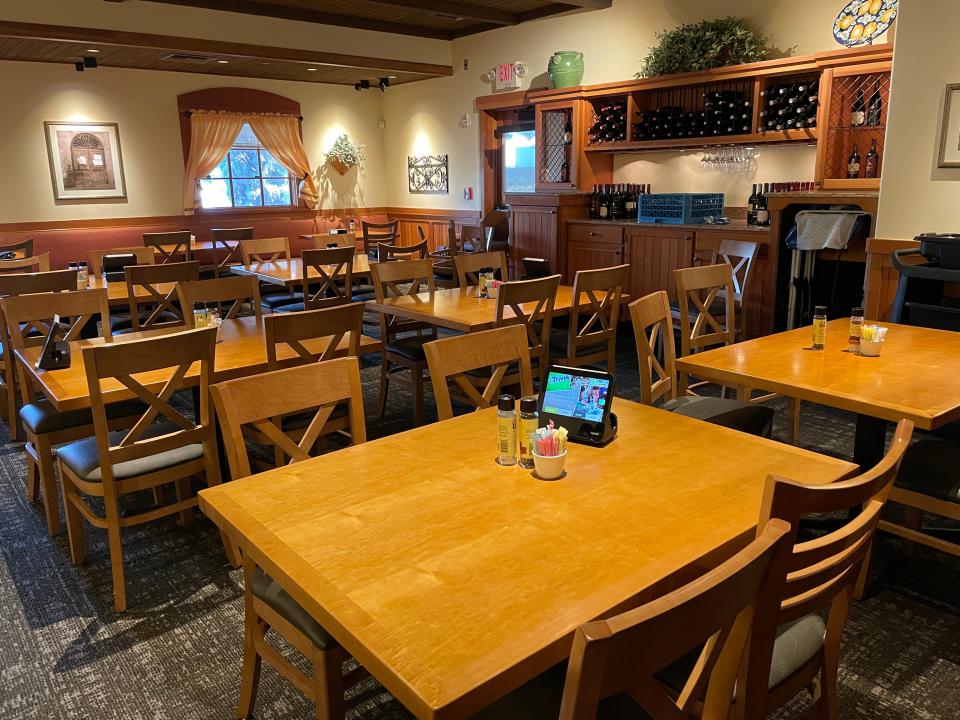 Light-brown wooden tables and wine rack at Olive Garden