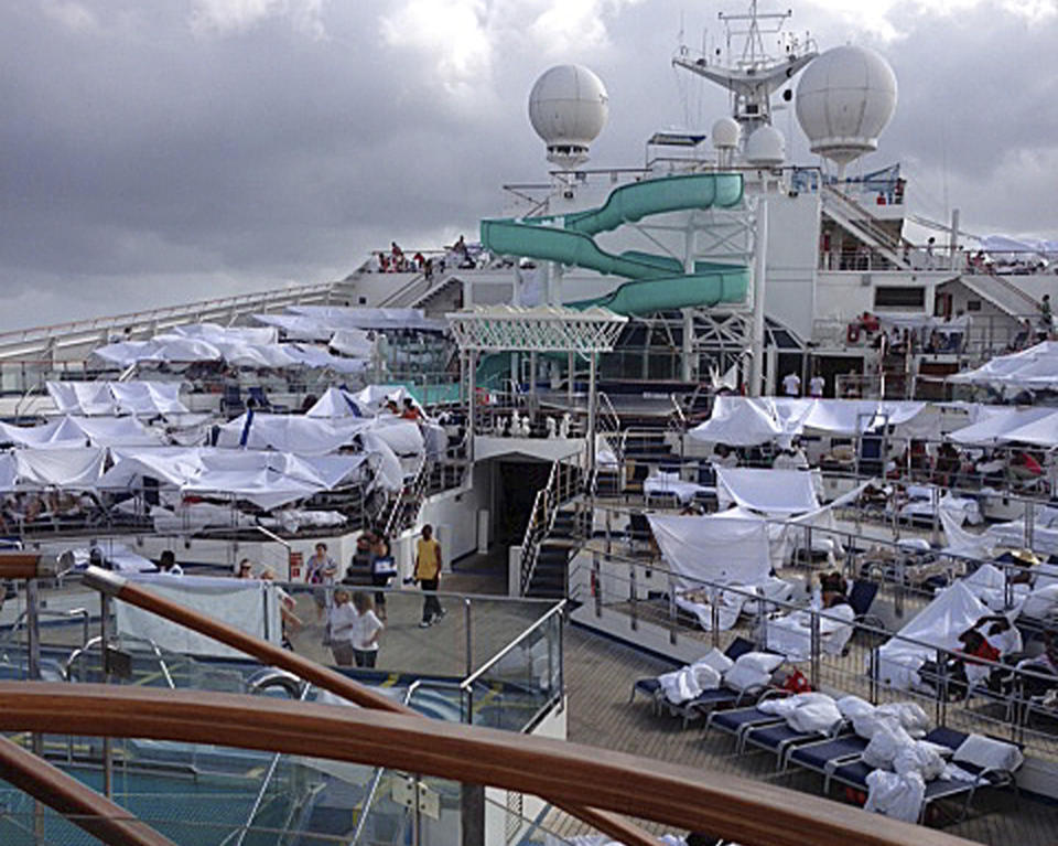 This Sunday, Feb. 10, 2013 photo, provided by Kalin Hill, of Houston, shows passengers with makeshift tents on the the deck of the Carnival Triumph cruise ship at sea in the Gulf of Mexico. The ship nearing Mobile Bay is without engine power and is being towed by tugboats. (AP Photo/Kalin Hill)