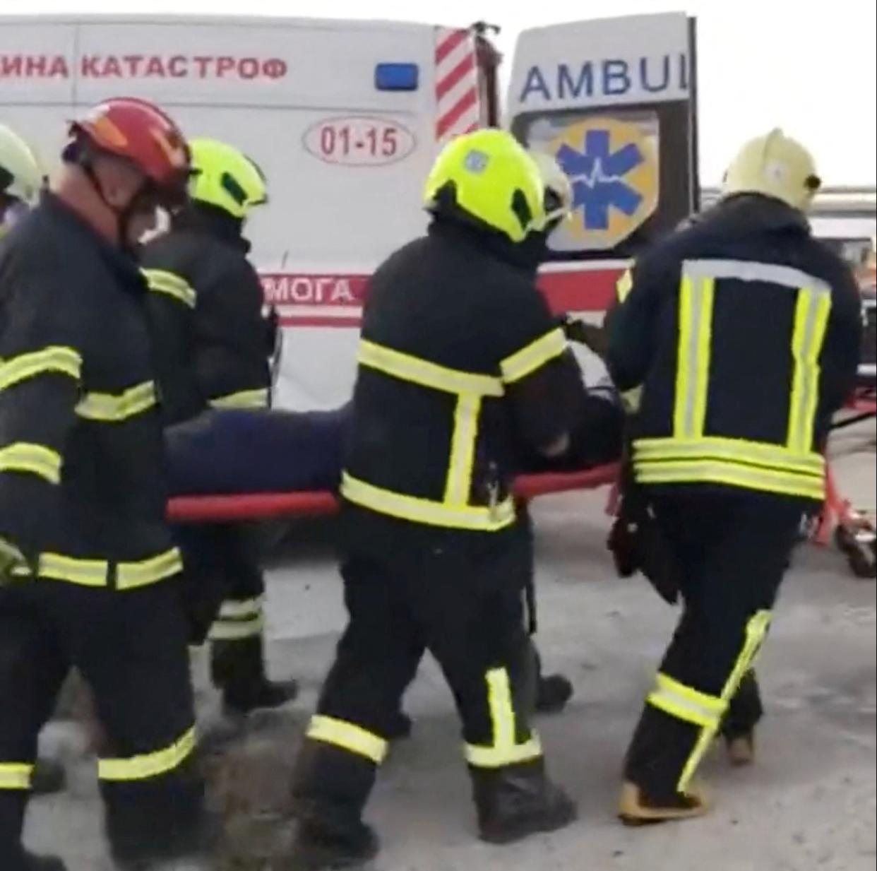 Ukrainian rescuers carry a man on a stretcher after he was pulled out from under the rubble (via REUTERS)