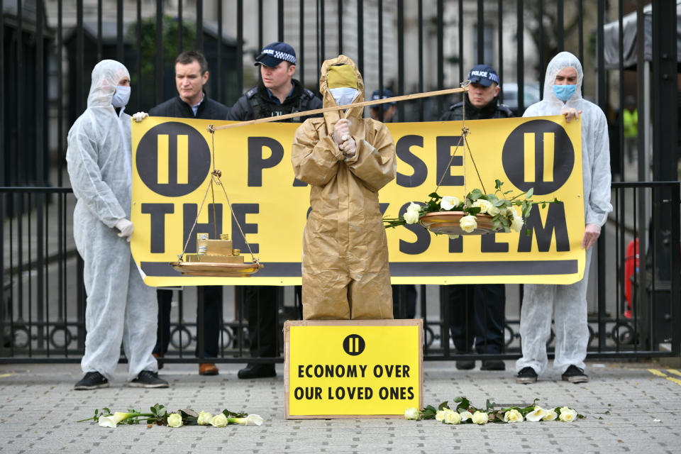 Protesters from a group called 'Pause the System' wear hazmat suits as they demonstrate outside Downing Street in London. The group are calling for greater action from the government as the UK's coronavirus death toll rose to 35 with a total of 1,372 positive tests for coronavirus in the UK as of 9am on Sunday.