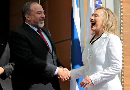 Israel's Foreign Minister Avigdor Lieberman shakes hands with then U.S. Secretary of State Hillary Clinton (R) before their meeting in Jerusalem July 16, 2012 in this file photo. REUTERS/Ammar Awad/File Photo