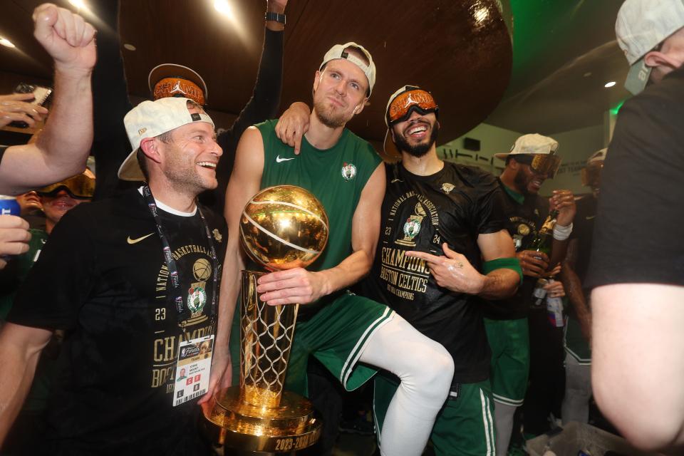 June 17, 2024; Boston, Massachusetts, USA; Boston Celtics center Kristaps Porzingis (center) and forward Jayson Tatum (right) celebrate with Celtics director of rehab Steve Mount in the locker room after winning the 2024 NBA Finals against the Dallas Mavericks at TD Garden. Mandatory credit: Elsa/Pool Photo-USA TODAY Sports