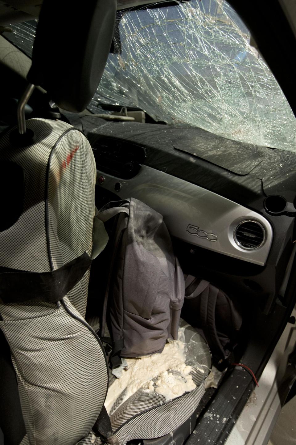 During a practice scenario displaying a fictional dirty bomb, part of the contents of a dirty bomb are spilled from a backpack onto the passenger seat of a car, as experts with the Netherlands Forensic Institue NFI show how to secure evidence from a fictional crime scene, during a meeting on security technology Thursday, March 20, 2014, in The Hague, Netherlands, ahead of the upcoming March 24 and 25 Nuclear Security Summit in The Hague. (AP Photo/Peter Dejong)