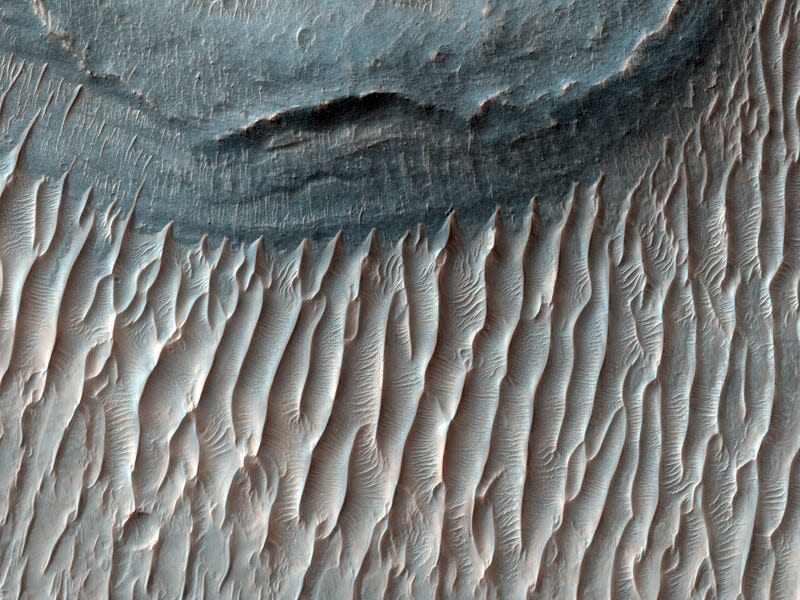 Ius Chasma shows signs of water and wind, which shaped these rock formations.