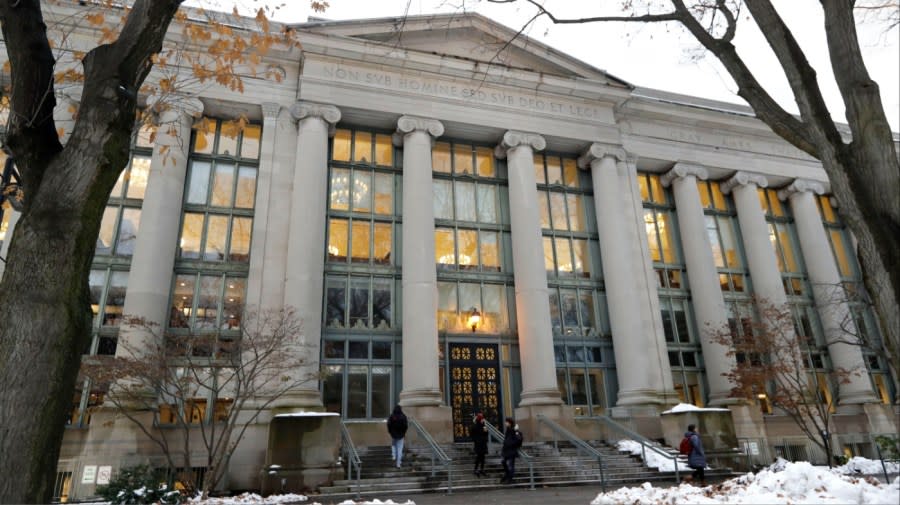 <em>In this Thursday, Dec. 5, 2019 photo, passers-by walk near an entrance to a building at Harvard Law School in Cambridge, Mass. (AP Photo/Steven Senne)</em>