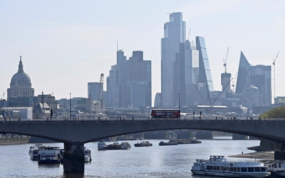 FILE PHOTO: Boats are anchored in the River Thames, with buildings in the City of London financial district seen behind, as the British government announced it was accelerating plans to protect London from flooding caused by a warming climate and rising sea levels, in London, Britain, May 17, 2023. REUTERS/Toby Melville/File Photo - REUTERS/Toby Melville