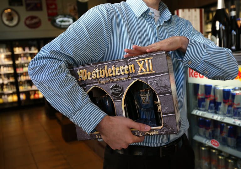 A customer holds a six-pack of Belgian Trappist beer at Ales Unlimited in San Francisco