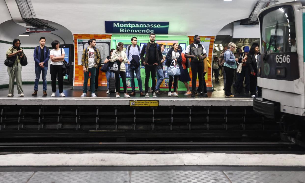 <span>Commuters wait for a metro train at Montparnasse Bienvenue station in Paris.</span><span>Photograph: Mohammed Badra/EPA</span>