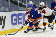 New York Islanders' Andy Greene (4) is defended by New Jersey Devils' Andreas Johnsson (11) and Nikita Gusev (97) during the third period of an NHL hockey game Thursday, Jan. 21, 2021, in Uniondale, N.Y. (AP Photo/Frank Franklin II)