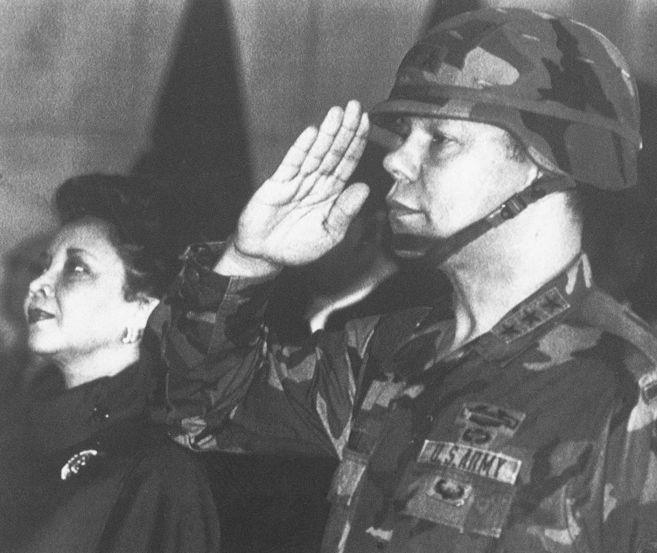 FILE - In this Dec. 30, 1986, file photo, U.S. Lieutenant General Colin Powell, commander of the 5th U.S. corps, salutes while his wife Alma stands in attention during a farewell ceremony in Frankfurt. Powell, who went on to become the chairman of the Joint Chiefs and U.S. secretary of state, has died from COVID-19 complications, his family said Monday, Oct. 18, 2021. (AP Photo/Udo Weitz)