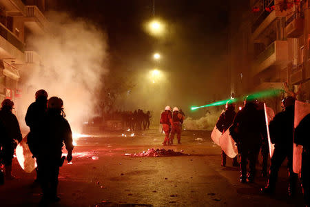 A protester shines a laser pointer at police during clashes following an anniversary rally marking the 2008 police shooting of 15-year-old student, Alexandros Grigoropoulos, in Athens, Greece, December 6, 2017. REUTERS/Costas Baltas