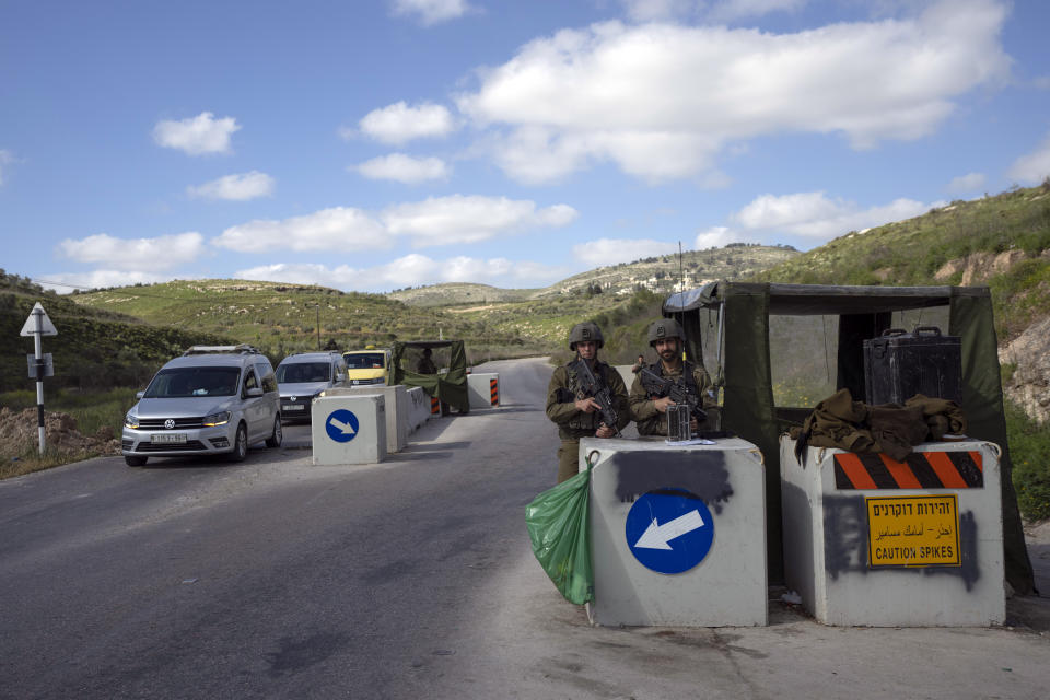 FILE - An Israeli army checkpoint controls a street leading to the West Bank city of Jenin, Tuesday, April 12, 2022. The Israeli military body in charge of civilian affairs in the occupied West Bank has developed a new policy that would heavily regulate entry into the territory. (AP Photo/Nasser Nasser, File)