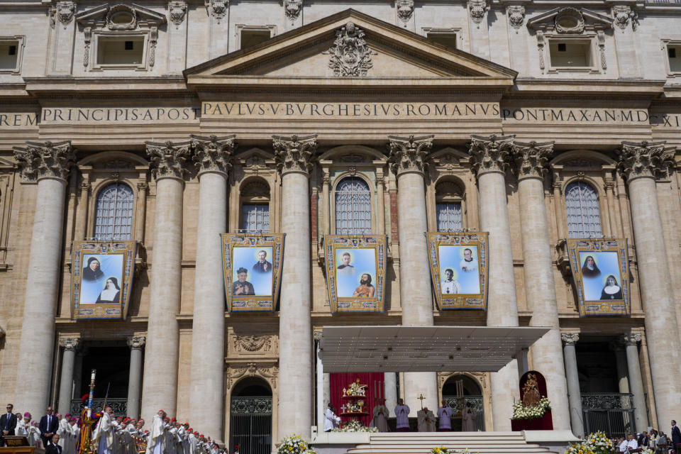 The tapestries depicting ten new saints, from left and top to bottom, Marie Rivier (1768-1838), Maria Francesca di Gesù Rubatto (1844-1904), César de Bus (1544-1607), Luigi Maria Palazzolo (1827-1886), Titus Brandsma (1881-1942), Lazzaro alias Devasahayam (1712-1752), Giustino Maria Russolillo (1891-1955), Charles de Foucauld (1858-1916), Maria di Gesù Santocanale (1852-1923), and Maria Domenica Mantovani (1862-1934) hang in St. Peter's Square at The Vatican, Sunday, May 15, 2022, during their canonization mass celebrated by Pope Francis. Francis created ten new saints on Sunday, rallying from knee pain that has forced him to use a wheelchair to preside over the first canonization ceremony at the Vatican in over two years. (AP Photo/Gregorio Borgia)