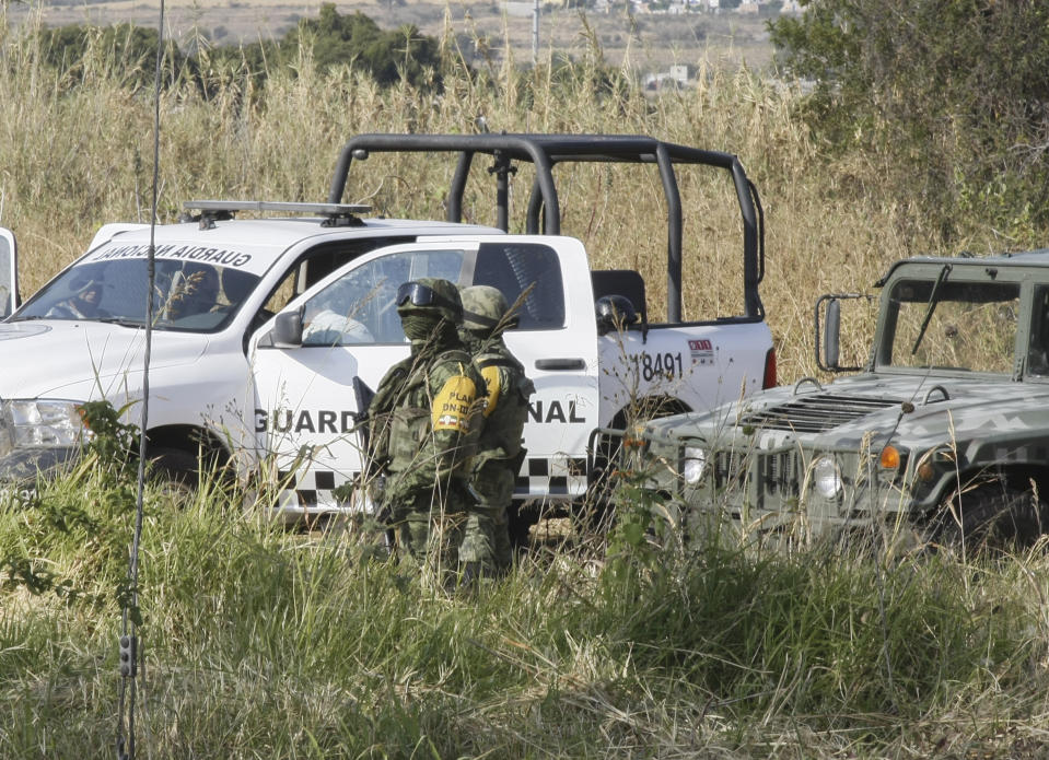 Soldiers stand guard near the site where mass graves were found in Salvatierra, Guanajuato state, Mexico, Thursday, Oct. 29, 2020. A Mexican search group said Wednesday it has found 59 bodies in a series of clandestine burial pits in the north-central state of Guanajuato, and that more could still be excavated. (AP Photo/Mario Armas)