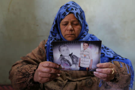 Ayat el-Sayed poses holding a photograph of her teenage son El-Sayed Raaouf at the family home in the village of Kafr Dewaeda, in the province of Al-Sharkia, Egypt, November 23, 2016. REUTERS/Mohamed Abd El Ghany