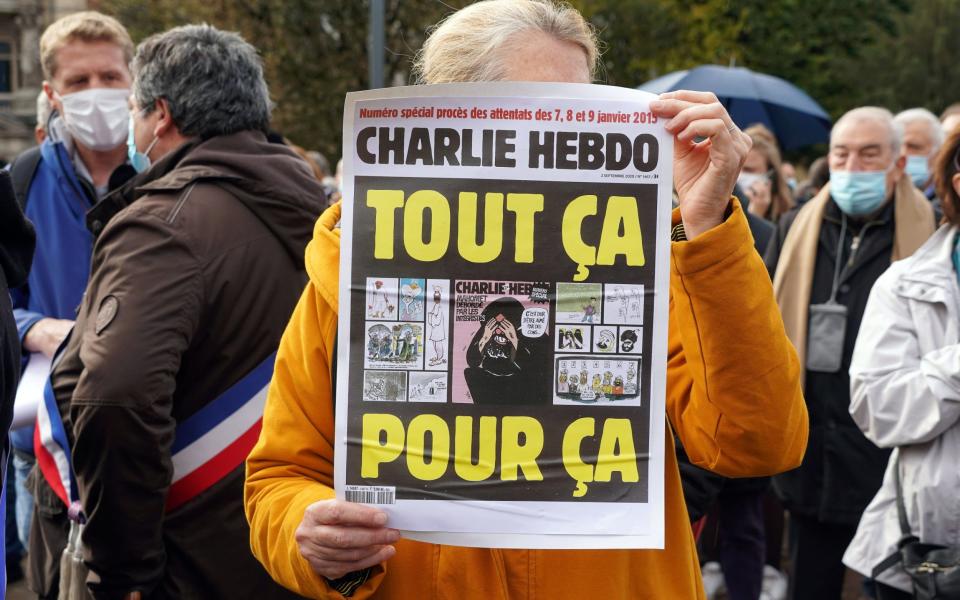 A woman holds a sign saying: "Charlie Hebdo. All for this" during the rally in memory of Samuel Paty in Lille - Sylvain Lefevre/Getty Images
