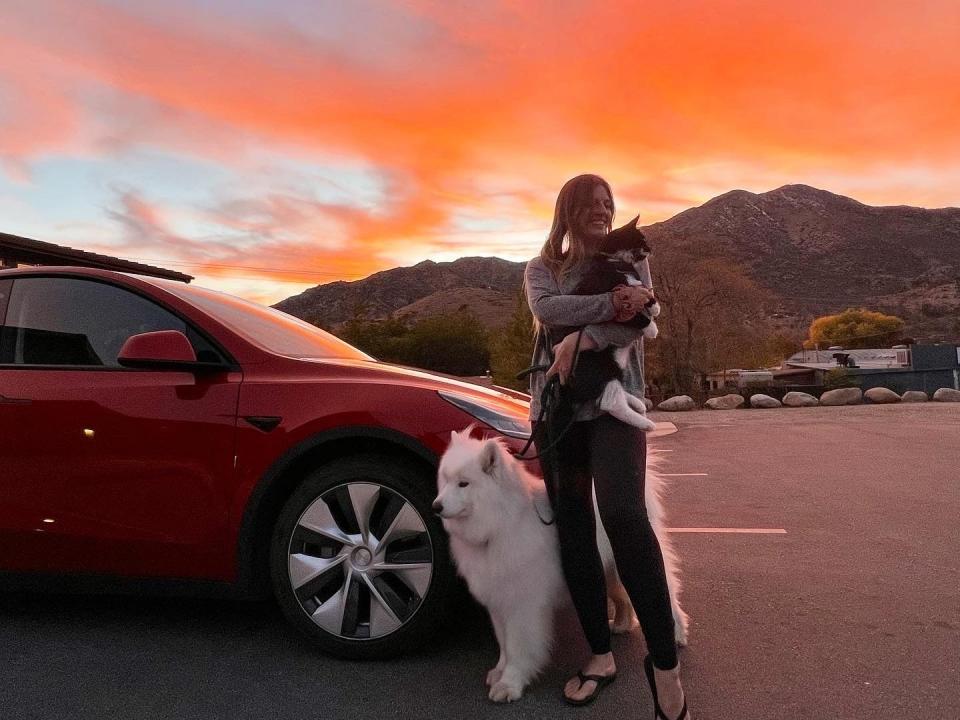 A picture of Virovec with her dog and cat standing next to a mountain.