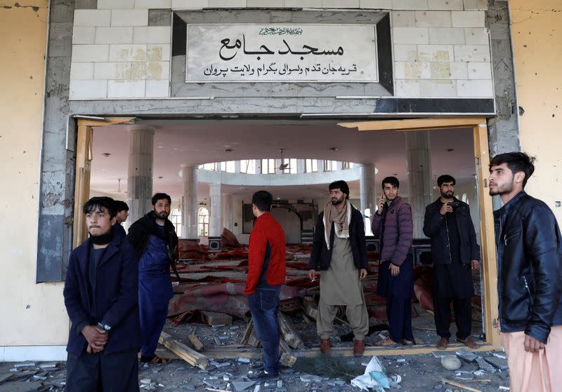 Residents inspect a damaged mosque at the site of an attack in a U.S. military air base in Bagram