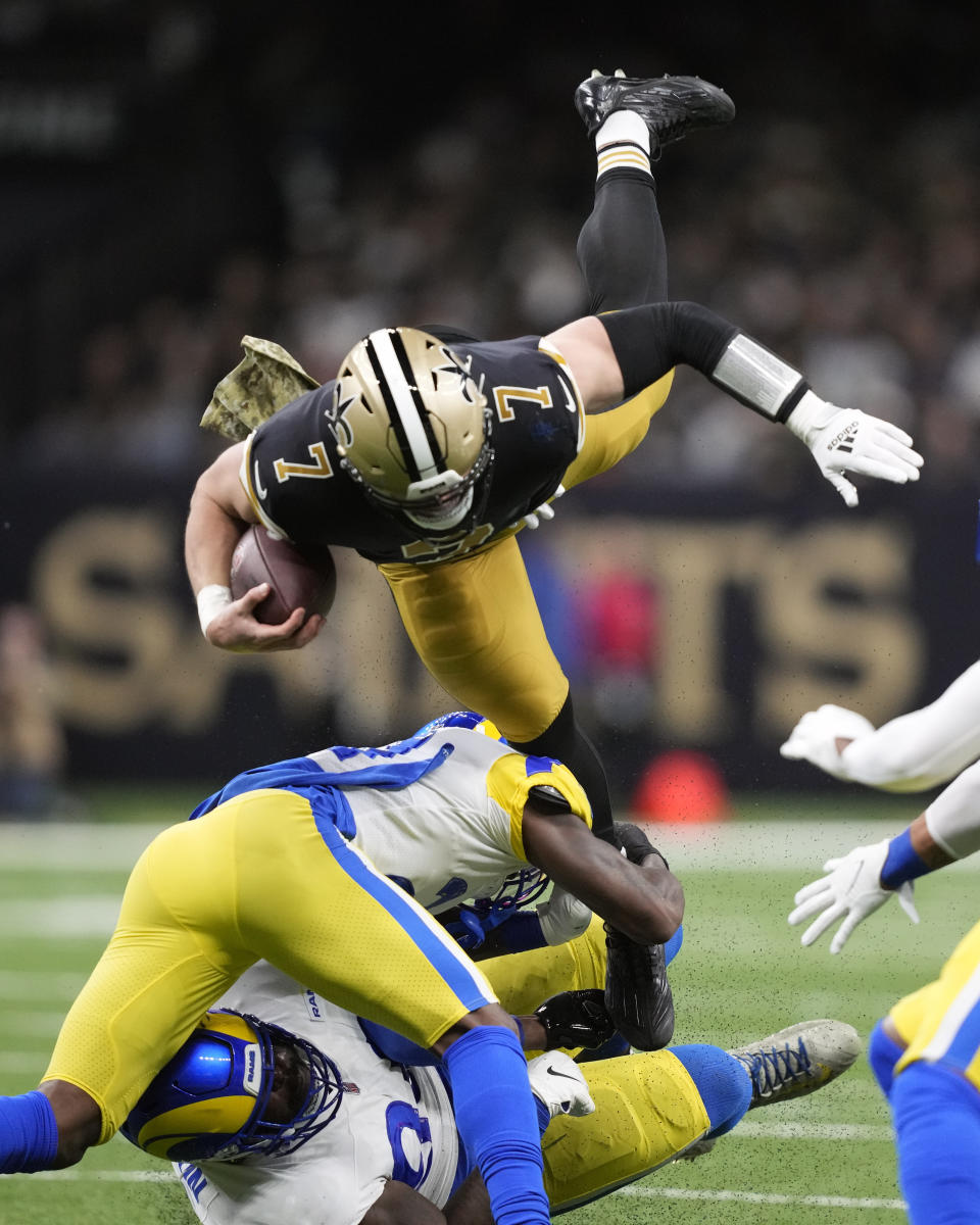 New Orleans Saints' Taysom Hill (7) is tripped up by Los Angeles Rams defenders in the first half of an NFL football game in New Orleans, Sunday, Nov. 20, 2022. (AP Photo/Gerald Herbert)