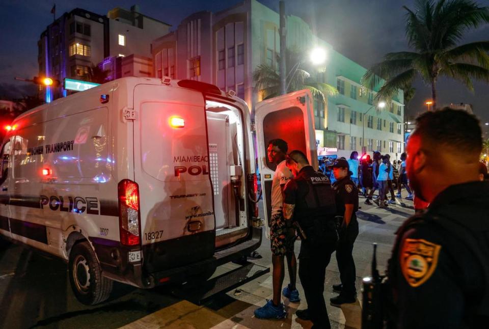 Agentes de policía de Miami Beach subiendo a un detenido en un auto de transporte policial en Ocean Drive durante las vacaciones de primavera en Miami Beach, la Florida, el sábado 16 de marzo de 2024.