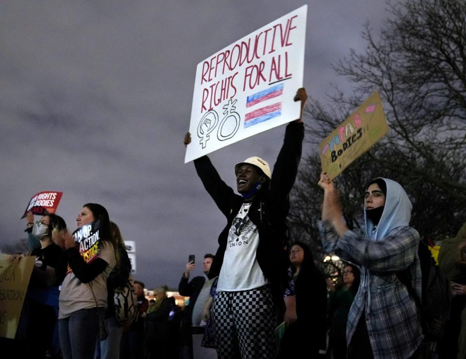 Johnson and Wales student Tripp Hopkins stands with Tam Snow (far right) of Providence, Rhode Island holding their signs supporting abortion rights at a rally at the Rhode Island State House in reaction to the leaked Supreme Court memo hinting a possible reversal of Roe vs. Wade.