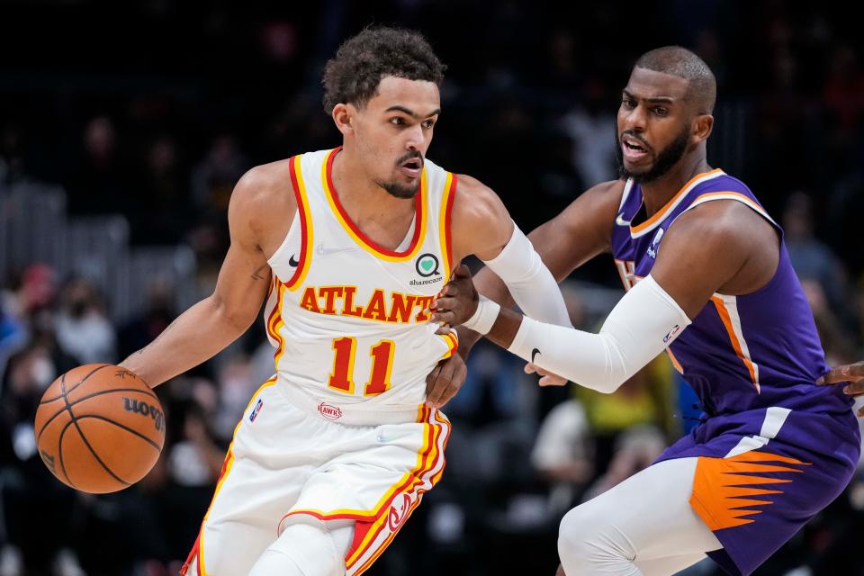 Atlanta Hawks guard Trae Young (11) dribbles against Phoenix Suns guard Chris Paul (3) during the first quarter at State Farm Arena in Atlanta on Feb. 3, 2022.