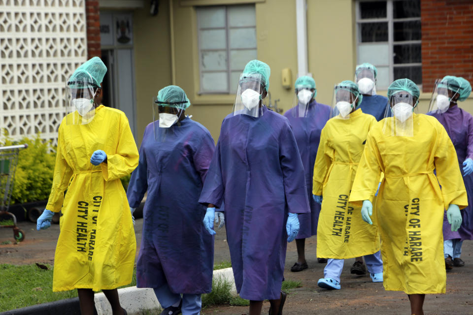 FILE - In this Thursday, Feb, 18, 2021 file photo, health workers walk together at a hospital where China's Sinopharm vaccine was being administered in Harare, Zimbabwe. Official figures show that 4% of the country’s 15 million population are fully immunized. The figures make Zimbabwe a relative success in Africa, where fewer than 2% of the continent’s 1. 3 billion people have been vaccinated, according to the World Health Organization. (AP Photo/Tsvangirayi Mukwazhi)