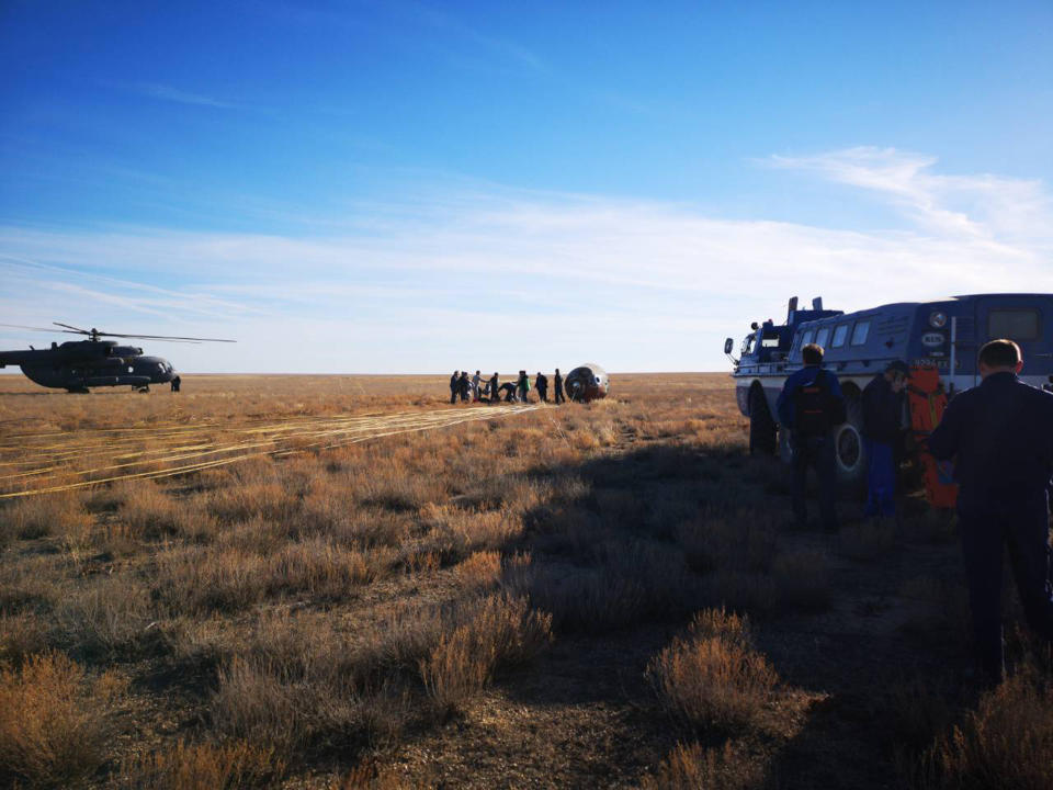 In this photo provided by Russian Defense Ministry Press Service, the rescue team gather next to the Soyuz MS-10 space capsule after it made an emergency landing in a field about 20 km (12,43 miles) Dzhezkazgan, about 450 kilometers (280 miles) northeast of Baikonur, Kazakhstan, Thursday, Oct. 11, 2018. NASA astronaut Nick Hague and Roscosmos' Alexei Ovchinin lifted off as scheduled at 2:40 p.m. (0840 GMT; 4:40 a.m. EDT) Thursday from the Russian-leased Baikonur cosmodrome in Kazakhstan, but their Soyuz booster rocket failed about two minutes after the launch. (Russian Defense Ministry Press Service photo via AP)