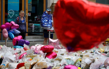 Runners competing in the Great Manchester Run look at floral tributes for the victims of the Manchester Arena attack, in St Ann's Square, in central Manchester, Britain May 28, 2017. REUTERS/Phil Noble