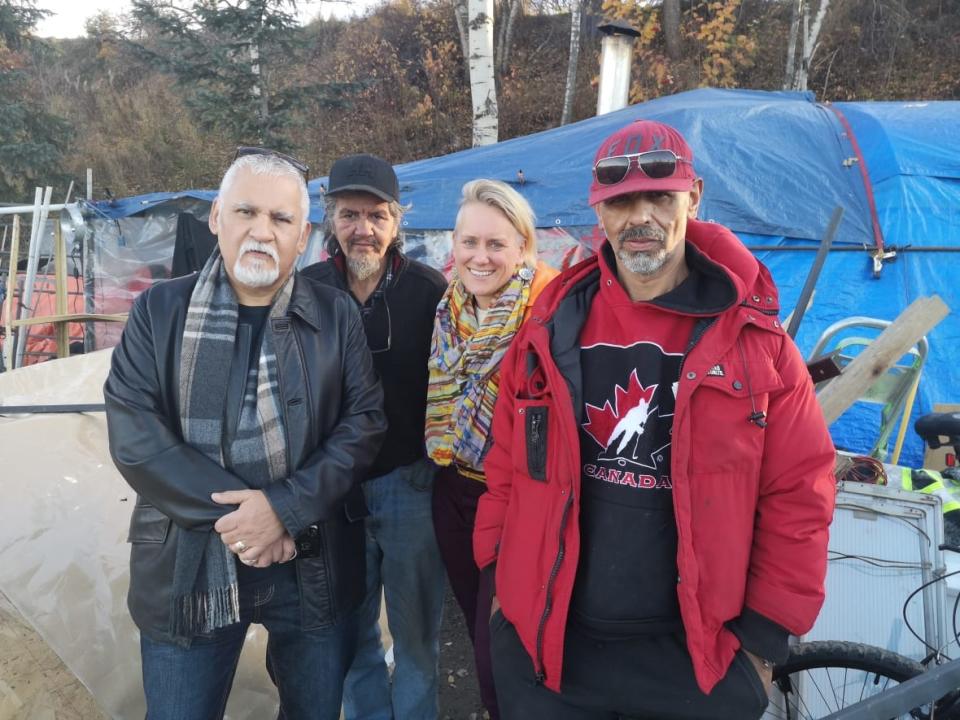 Homeless advocates Ivan Paquette (left) and Amelia Merrick (centre-right) celebrate with homeless camp residents Bell Johnny (centre left) and Jim Santos after a B.C. Supreme Court judge ruled the encampment Johnny and Santos live in will be allowed to stand in Prince George, B.C. (Jason peters - image credit)