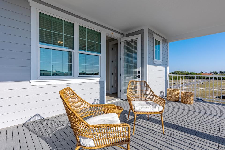 Balcony of Hunters Point home with two wicker chairs