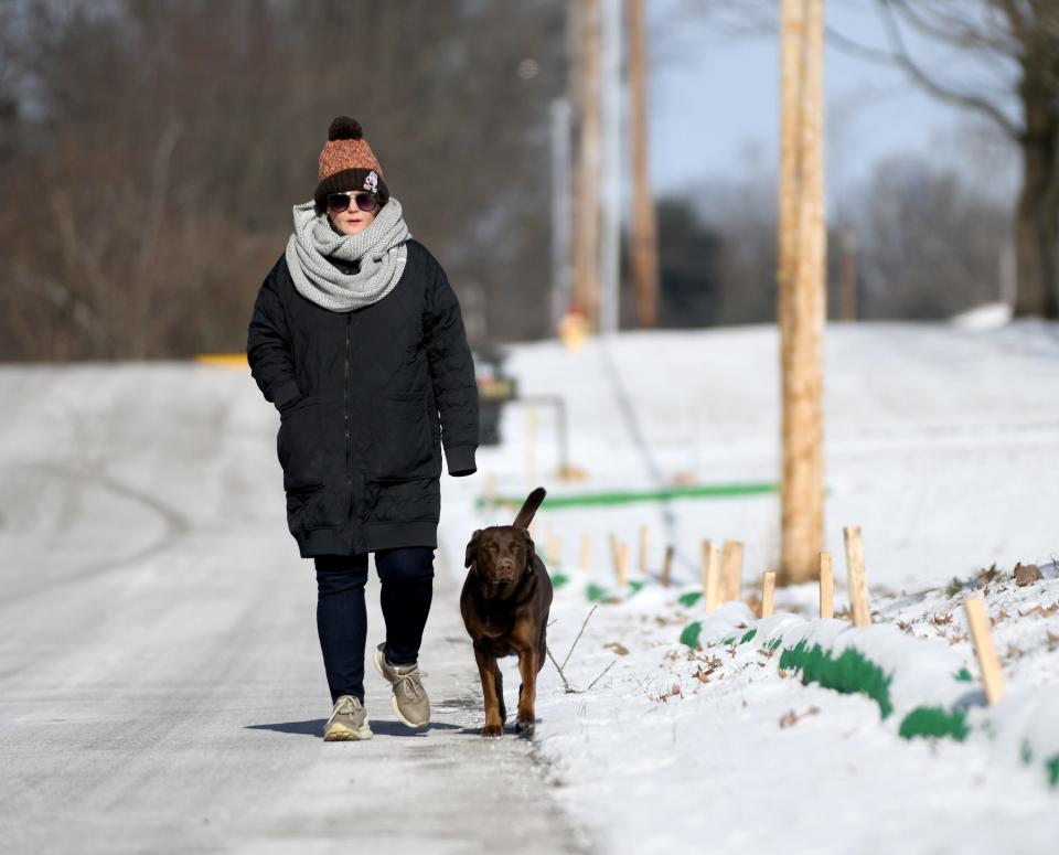 Melanie Elliott of Jackson Township takes Olive for a walk bundled against the extreme cold temperatures across the area.