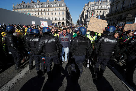 French gendarmes form a line ahead of protesters wearing yellow vests as they attend a demonstration by the "yellow vests" movement in Paris, France, February 23, 2019. REUTERS/Philippe Wojazer